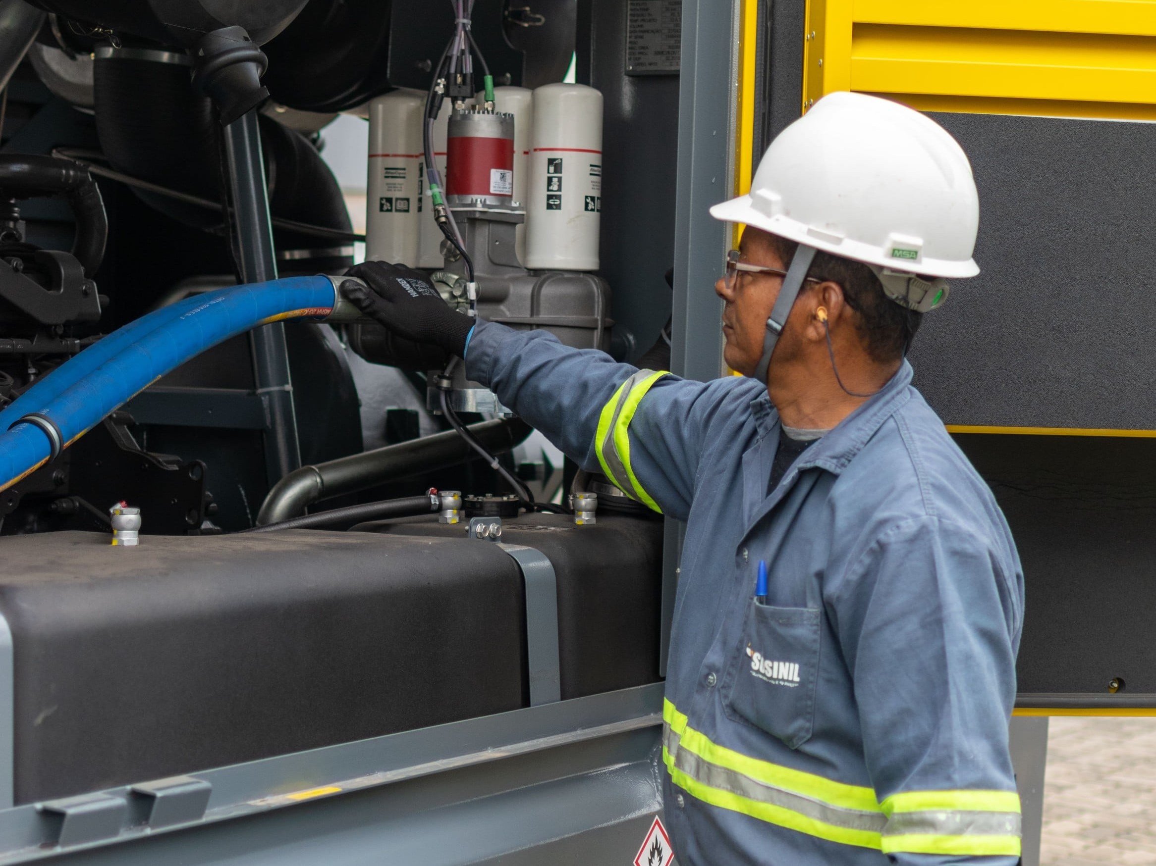 Técnico SOSINIL revisando compressor elétrico pronto para locação